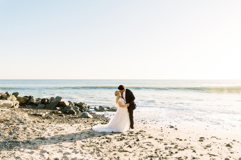 Bride and groom at Dana beach sharing a kiss at the beach