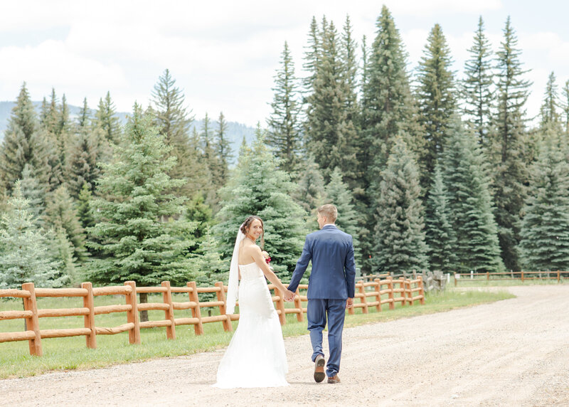 Cam and Lacey walking the fenceline near their ceremony at Lake Vallecito.