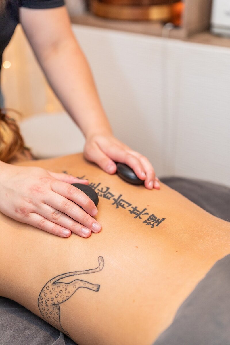 Hot stone massage at Rachel's Spa Services in Canfield, Ohio. A client relaxes as smooth, heated stones are placed on their back to relieve muscle tension and promote deep relaxation.