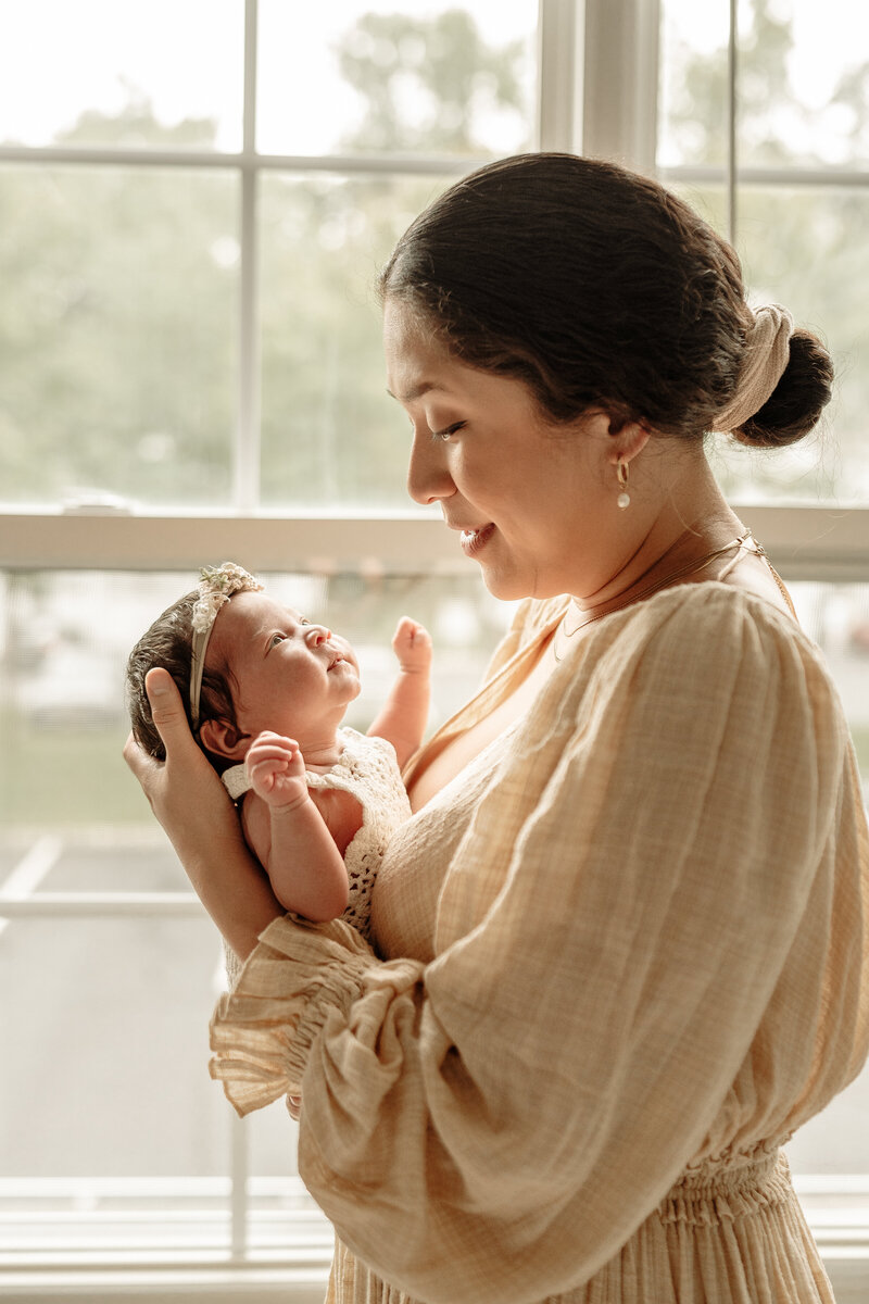 Mom staring at her newborn baby girl.