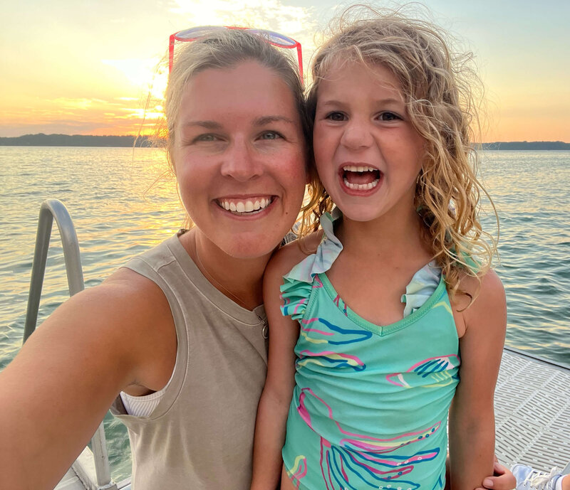 Alison and her daughter smiling for camera at sunset