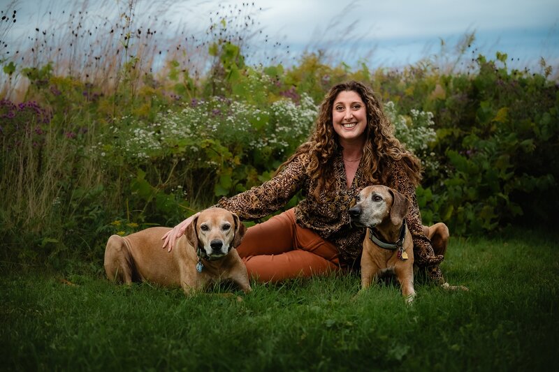 Portrait of woman with her two dogs sitting outside