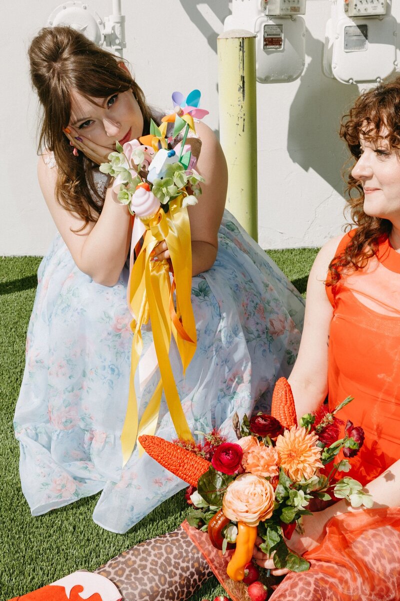 A woman sitting on a couch holding a disco ball over their head.