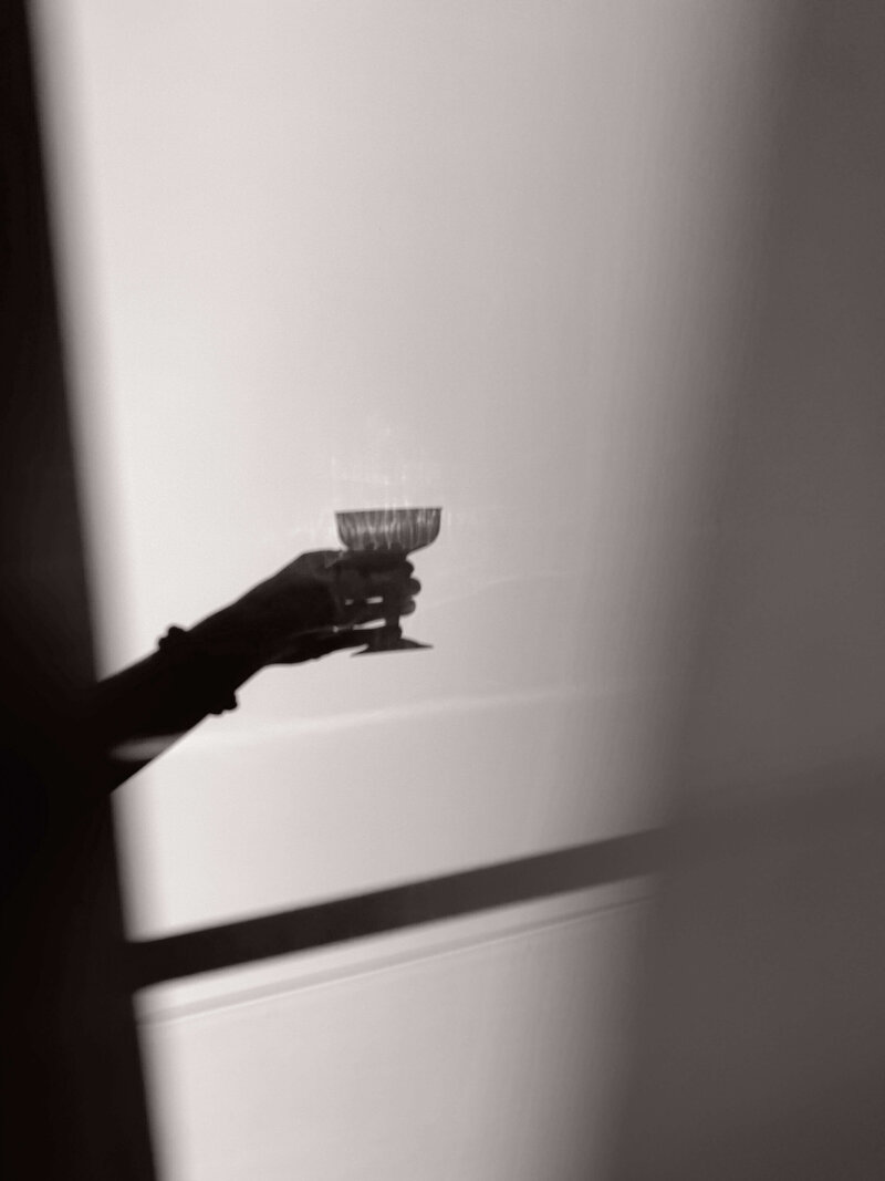 A shadow of a girl cheering with a glass