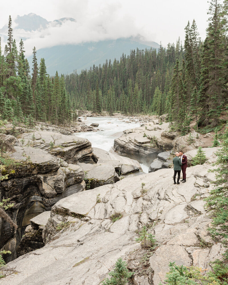 A same sex couple kiss surrounded by gorgeous nature views during their banff elopement