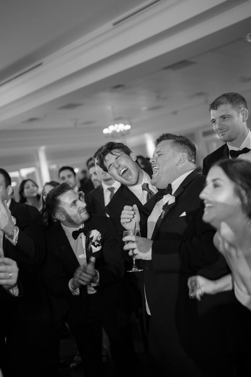 Black and white image of wedding guests singing at Cape May wedding reception