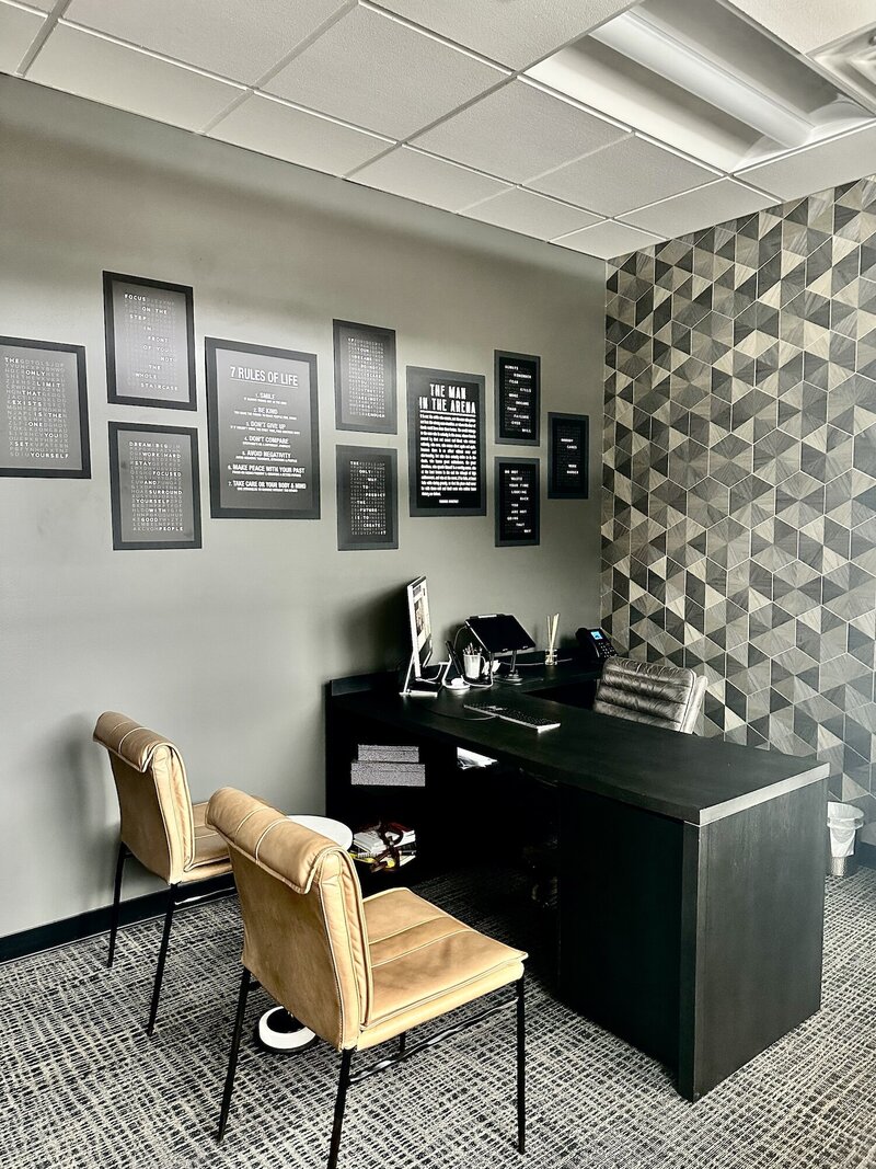 Light brown chairs a dark desk and a playful wallpaper.