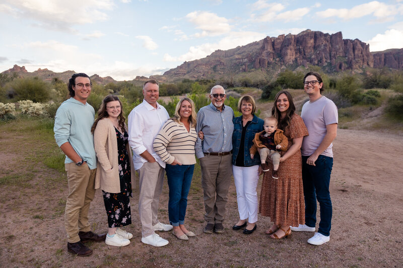 family smiling in front of superstition mountains