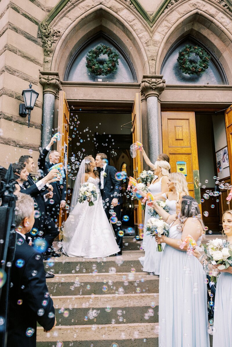 Bride and groom church exit with bubbles
