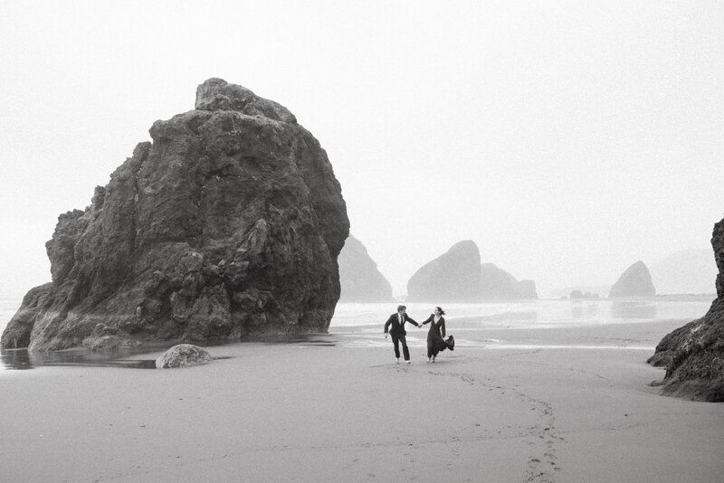 Couple eloping on a beach in Brookings, Oregon, exchanging vows with ocean views and a sunset backdrop.