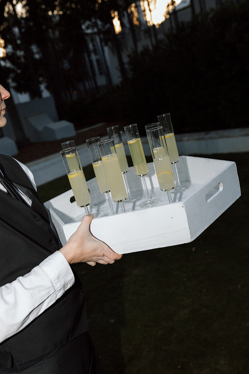 Server holding tray of lemon infused cocktails