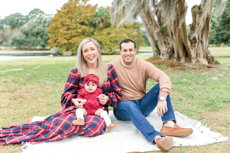 family sitting on a picnic blanket