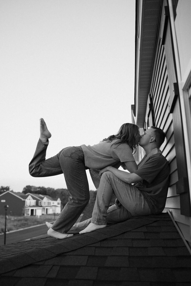 Minnesota and St Paul wedding photographer leans in to kiss her husband on their rooftop