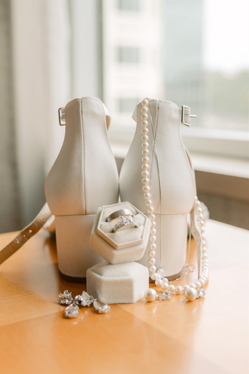 Wedding details, heels, jewelry, wedding rings, and earrings.