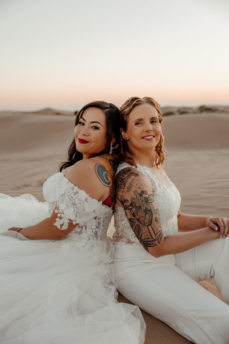 two woman sitting back to back