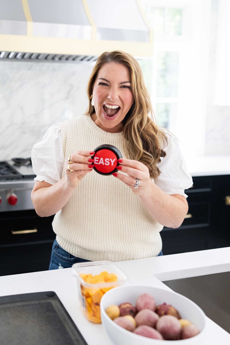 woman in with dark hair in cream shirt in kitchen with easy button
