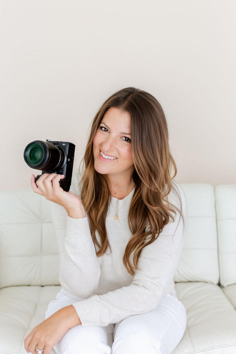 Jackie Averill  sitting holding her camera for a portrait