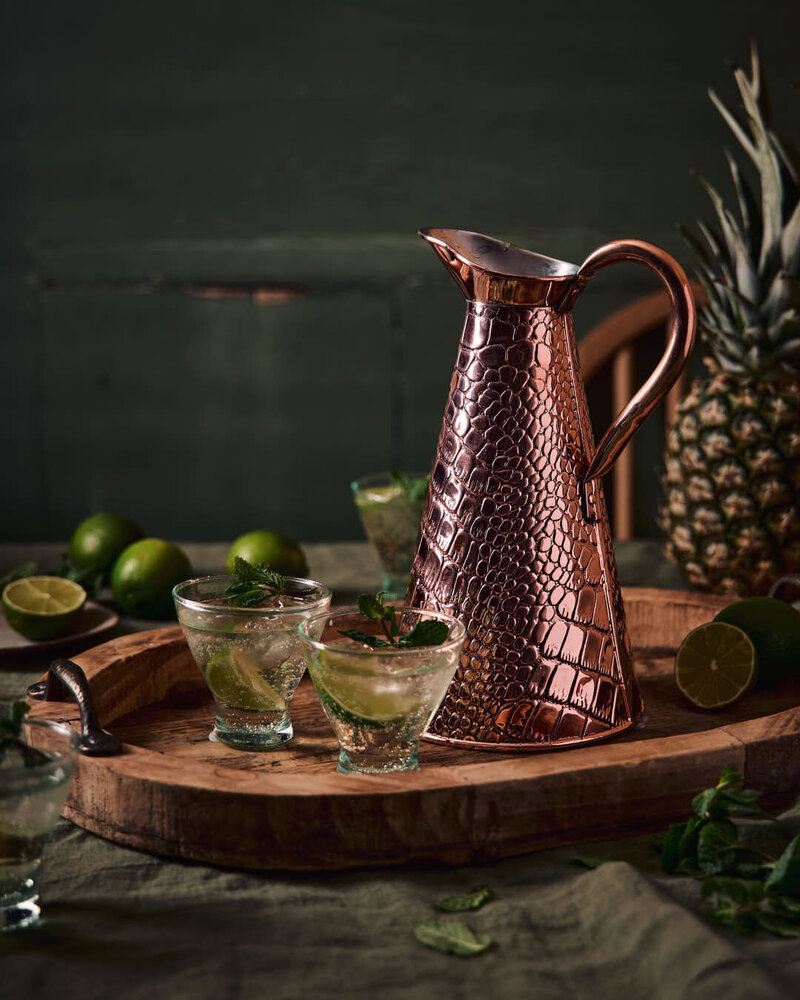 embossed water pitcher with drinks over a moody background