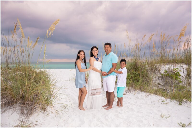 Family embrace each other on a beautiful cloudy day on the beach