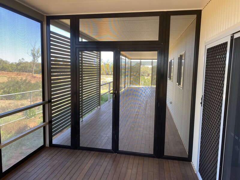 Contemporary patio enclosed with custom sliding glass doors for enhanced security and style.