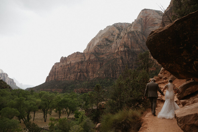 Couple hiking in wedding attire in Zion National Park for their Elopement