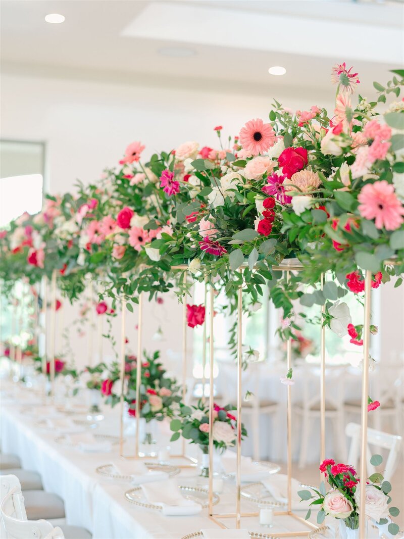 a luxury tall organically designed flower install with bright pink flower blooms