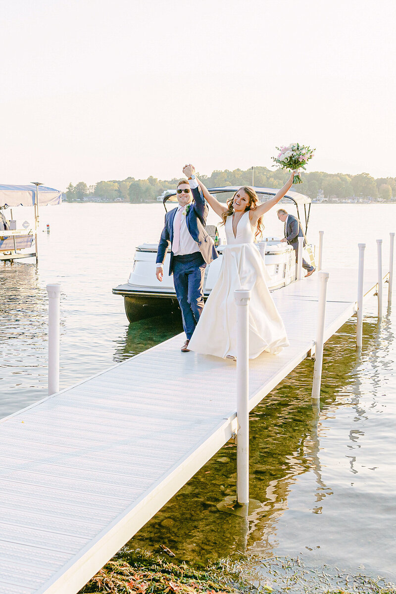 Bride and Groom getting off a boat as they enter their waterfront wedding reception on Diamond Lake