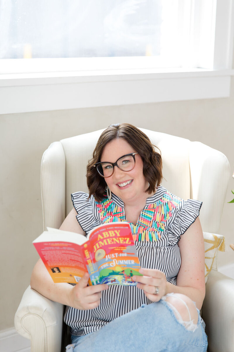 Sioux Falls bookstore owner Sara Gillis sitting in a chair and reading