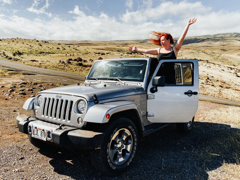 woman standing on the side of a Jeep