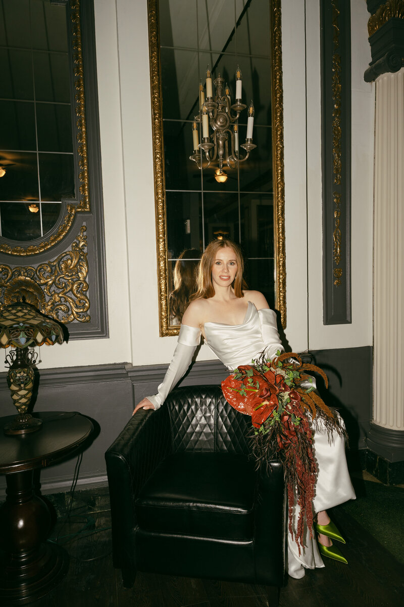 Bridal photo wearing green Prada pumps and an conventional flower bouquet with anthuriums, pops of red and green florals.