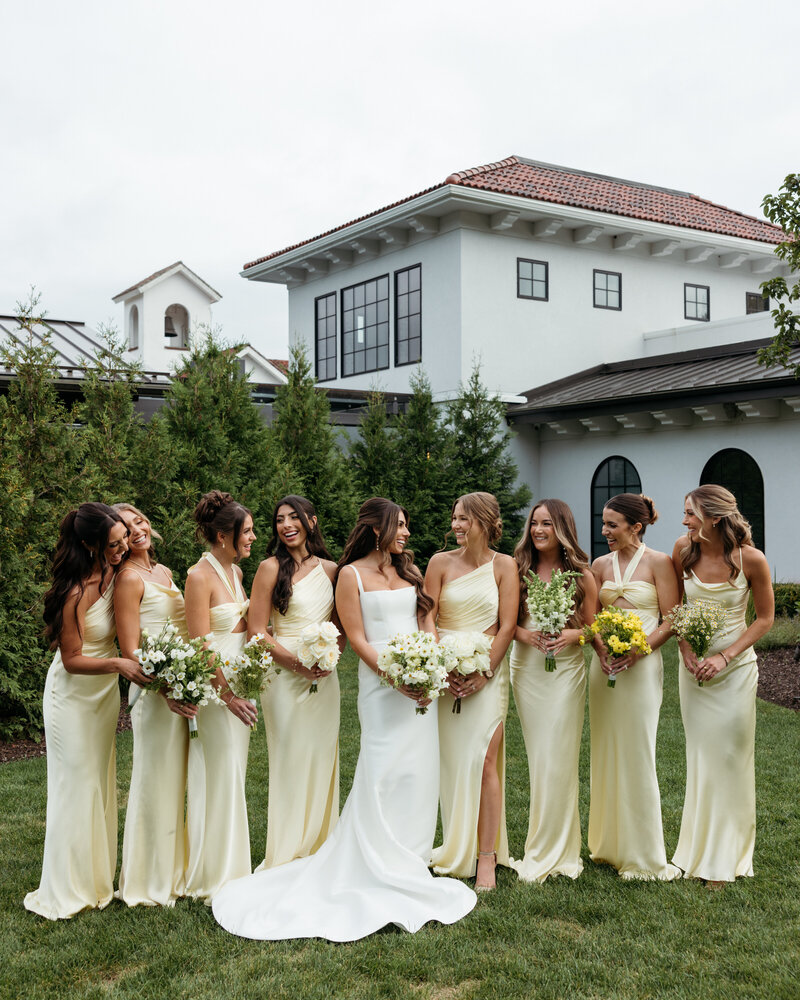 bride and groom standing next to each other while bride holds bridal bouquet