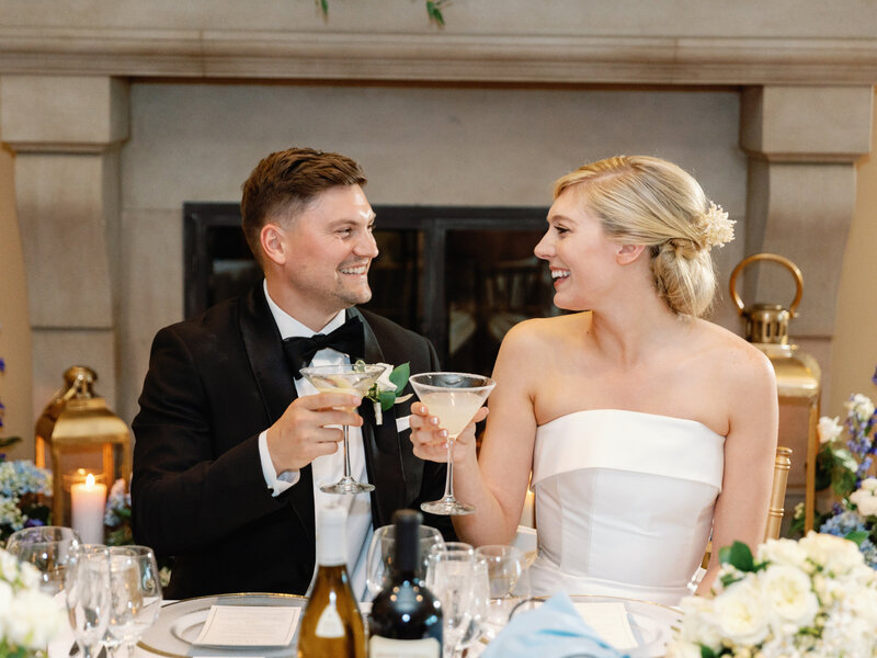 modern bride and groom toasting at their wedding reception sweetheart table