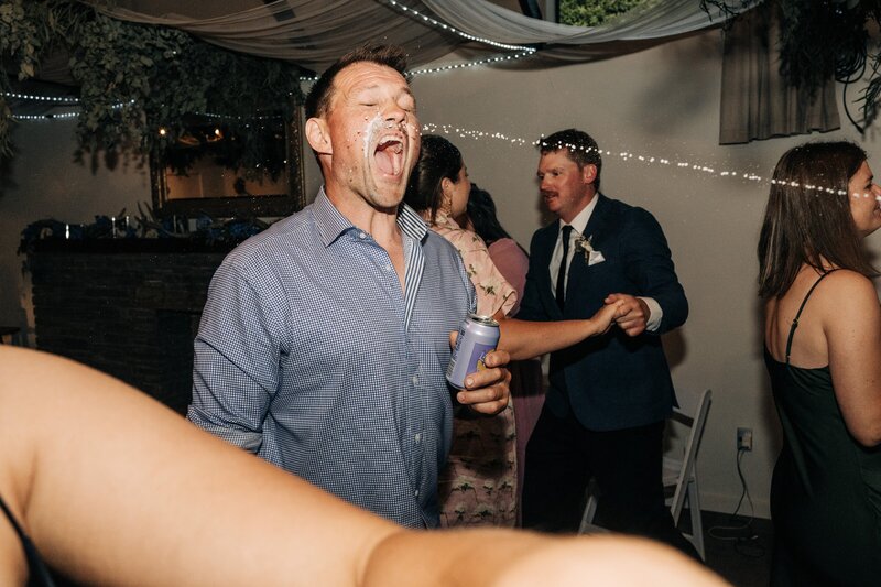 candid shot of man dancing at wedding in akaroa