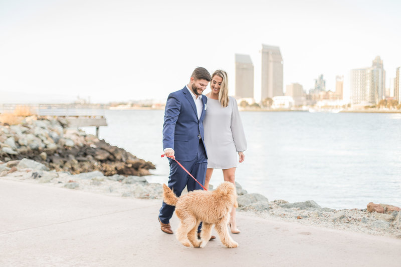 Couple with dog and san diego skyline background - san diego engagement session at coronado ferry landing 2
