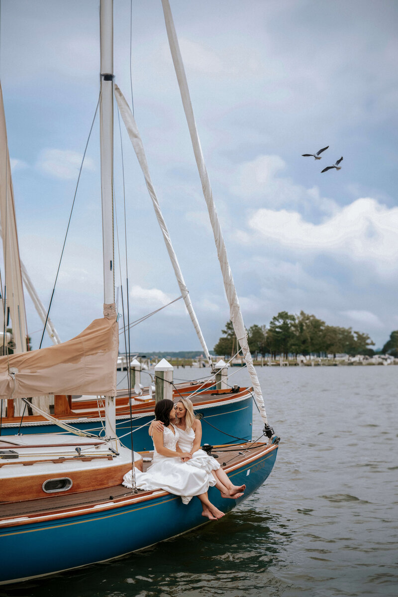 two-brides-sitting-on-boat-cuddling
