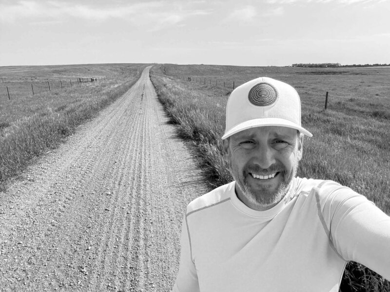 Lon Stroschein smiling on a country farm road reflecting on life after leaving corporate America
