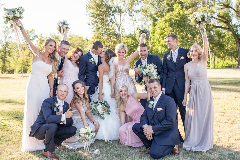 Bridesmaids in blush and sequin dresses with groomsmen cheering