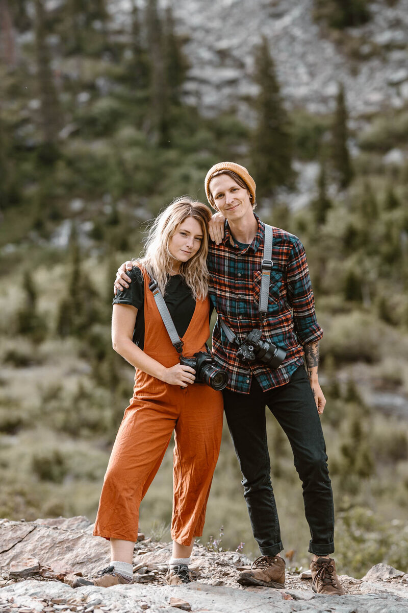 Sam and Kyle smile directly at the camera in a classic full body headshot image