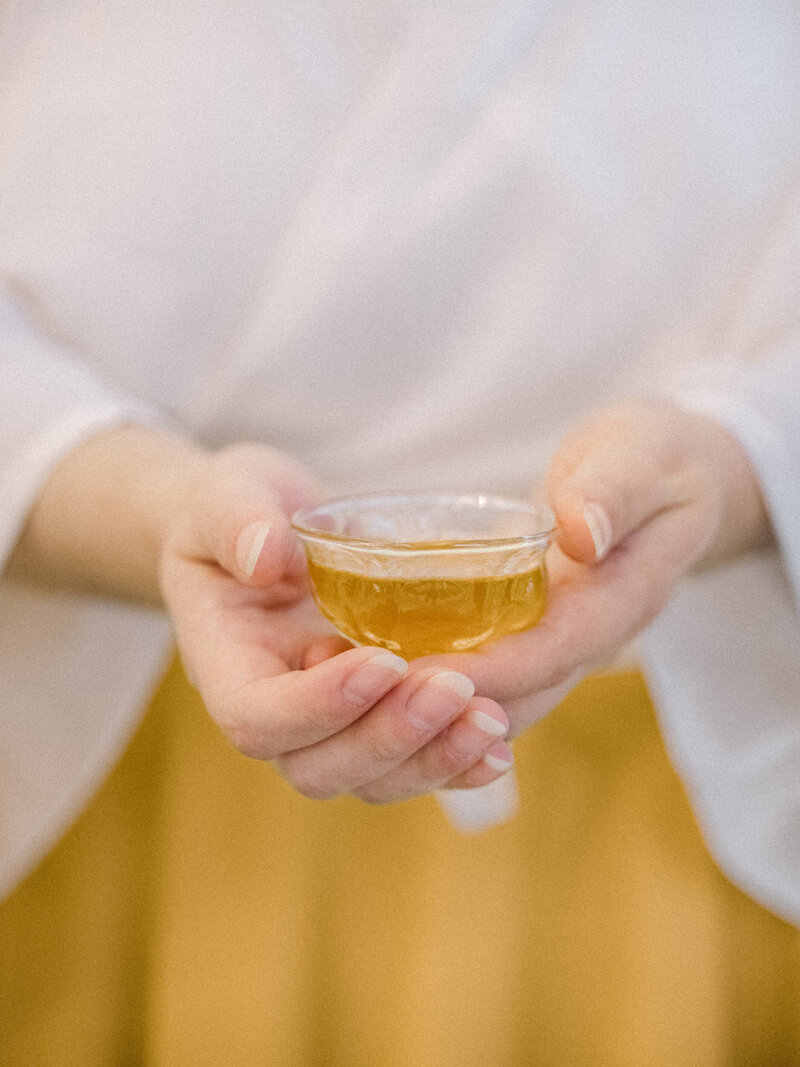 Business coach's hands offering a client a cup of tea