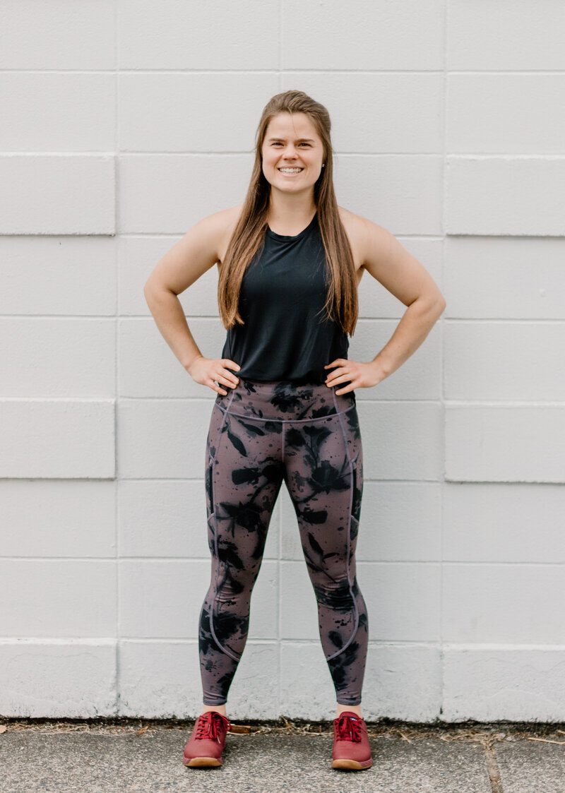 woman standing with her hands on her hips and smiling at the camera