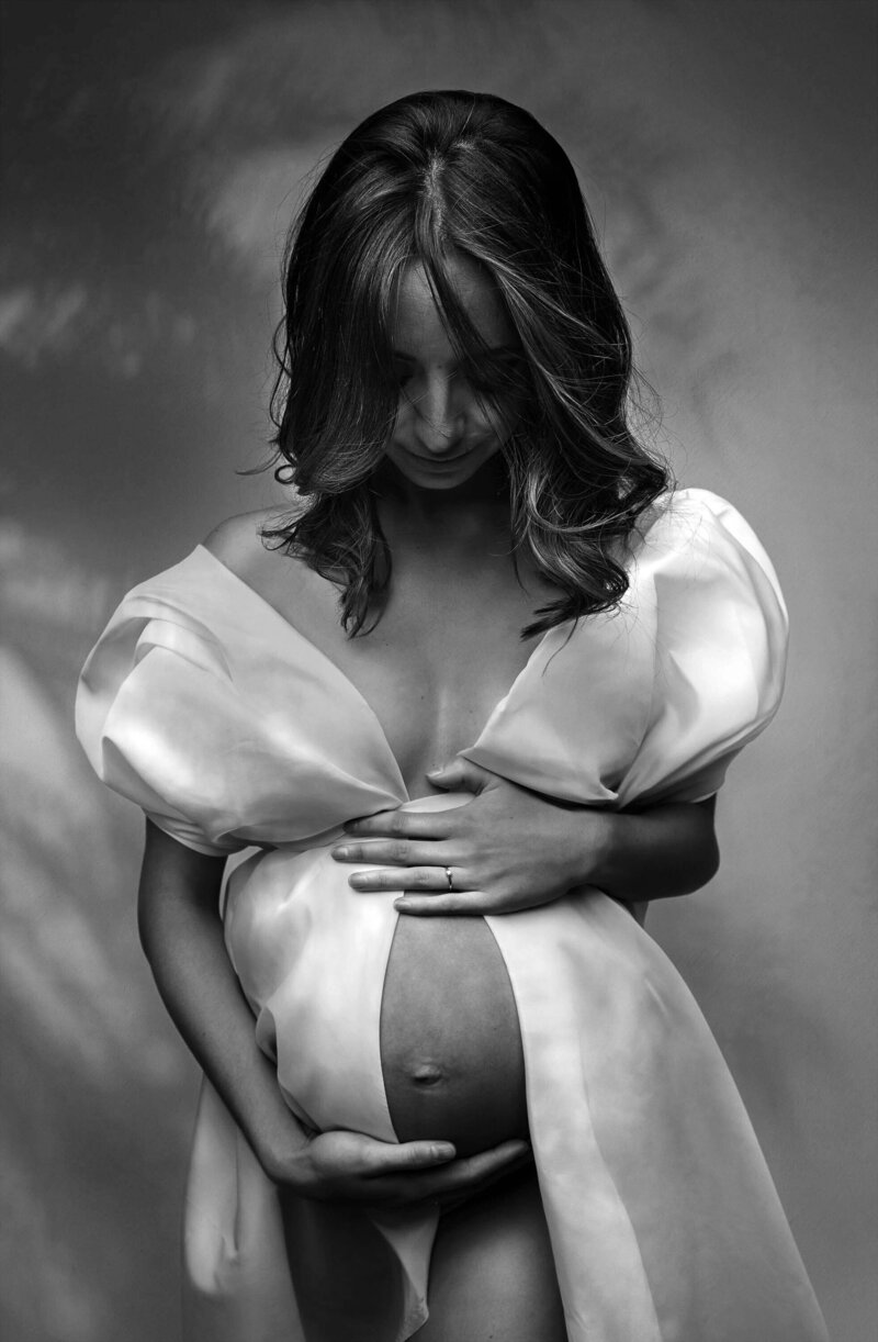 femme enceinte enveloppée dans une robe blanche décolletée