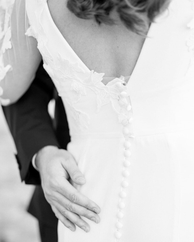 This intimate photograph captures the groom gently holding the back of his bride at the Banff Springs Hotel. The tender moment is beautifully framed by the hotel's elegant surroundings, highlighting the love and closeness between the couple on their special day.