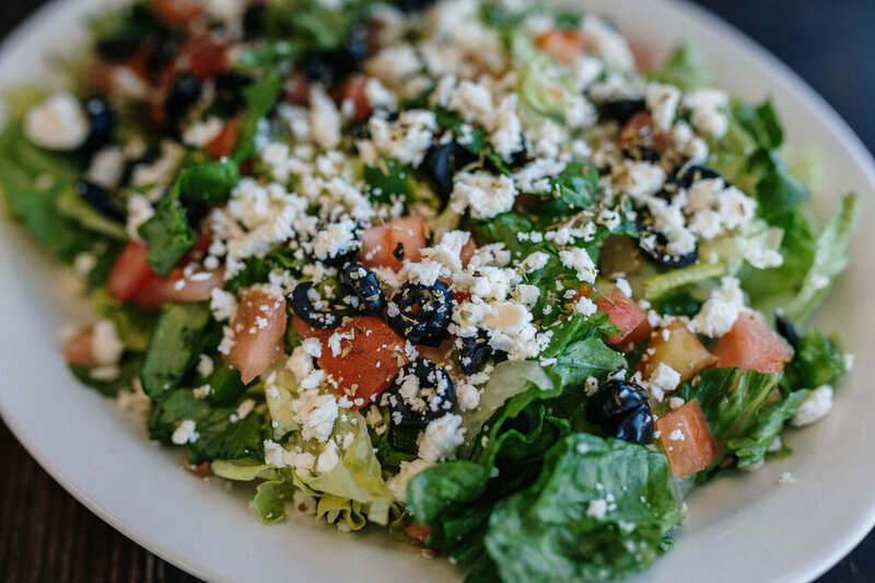 Fresh Greek salad from Redo’s Pizza with feta, olives, tomatoes, and crisp greens—served in Yarmouth and Wolfville, Nova Scotia