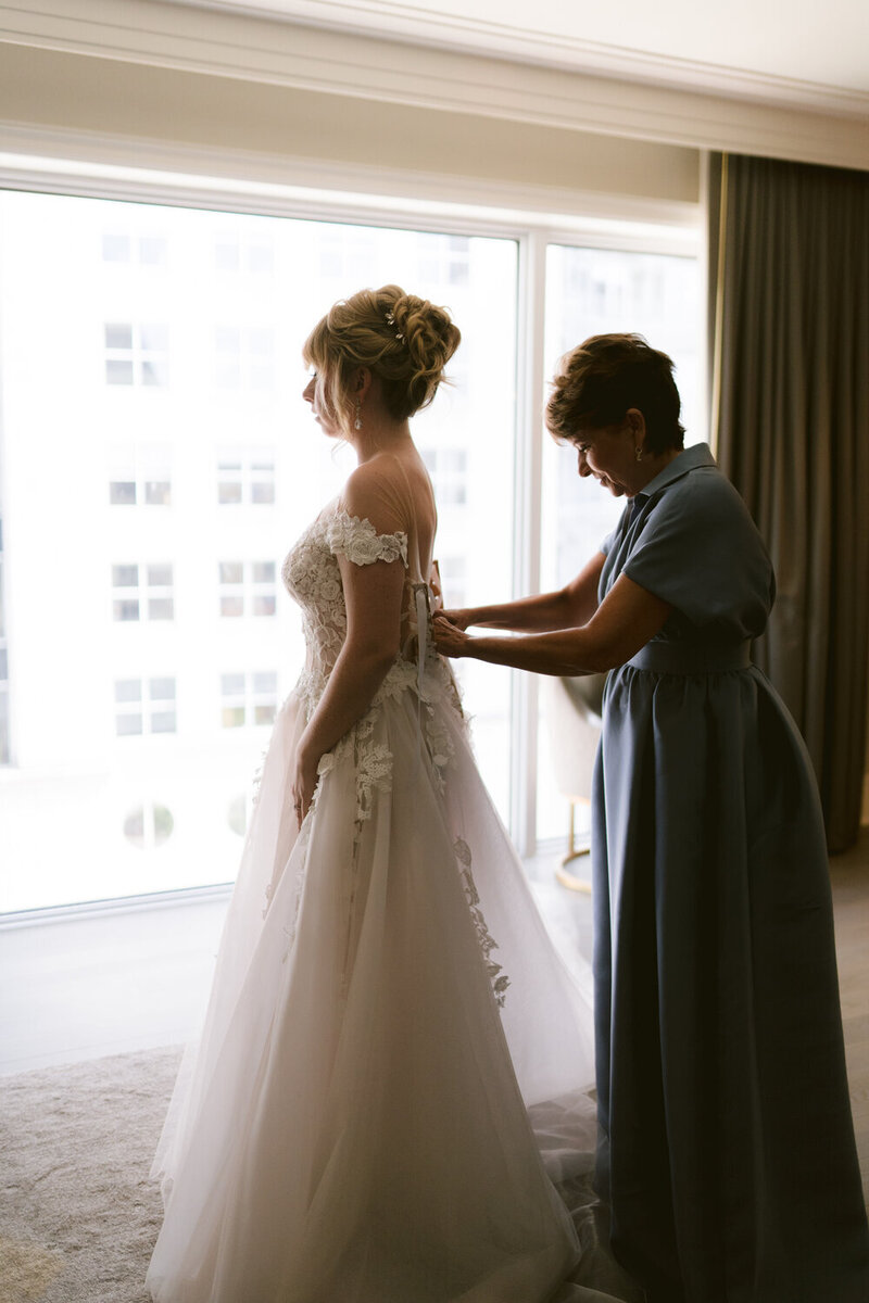Swank Soiree Dallas Wedding Planner Lauren and Ashton at the Crescent Hotel - bride putting on the wedding dress