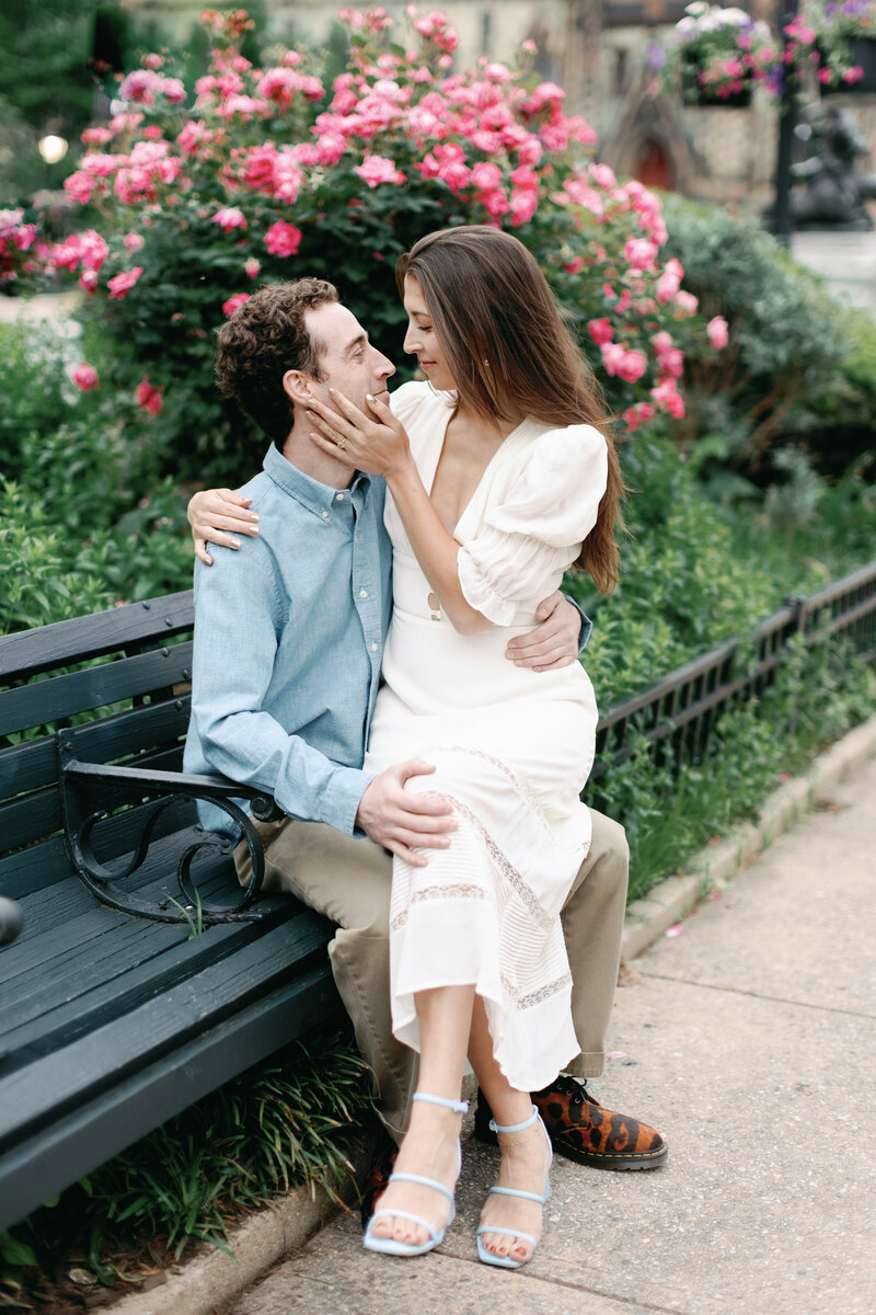 A couple embraces in a romantic moment in a rose garden