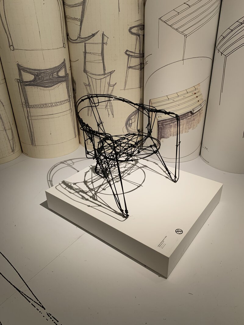 Scnadinavisch ontwerp van een stoel  in een lichte ruimte bij een groot raam met zwart kozijn