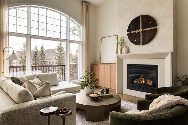 Stone fireplace with wallpaper and white oak cabinets. 