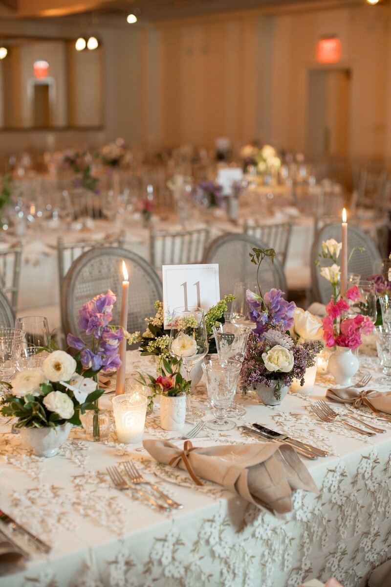 Reception tables decorated with florals, candles, and table settings