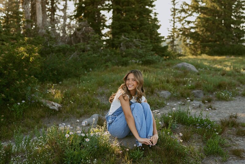 girl in red skirt and black sweater standing on hill in the forest