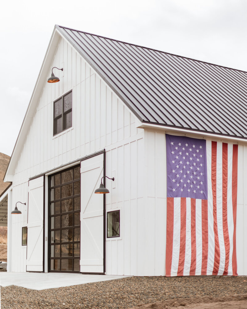 White Barn Outside American Flag Hanging Off Side